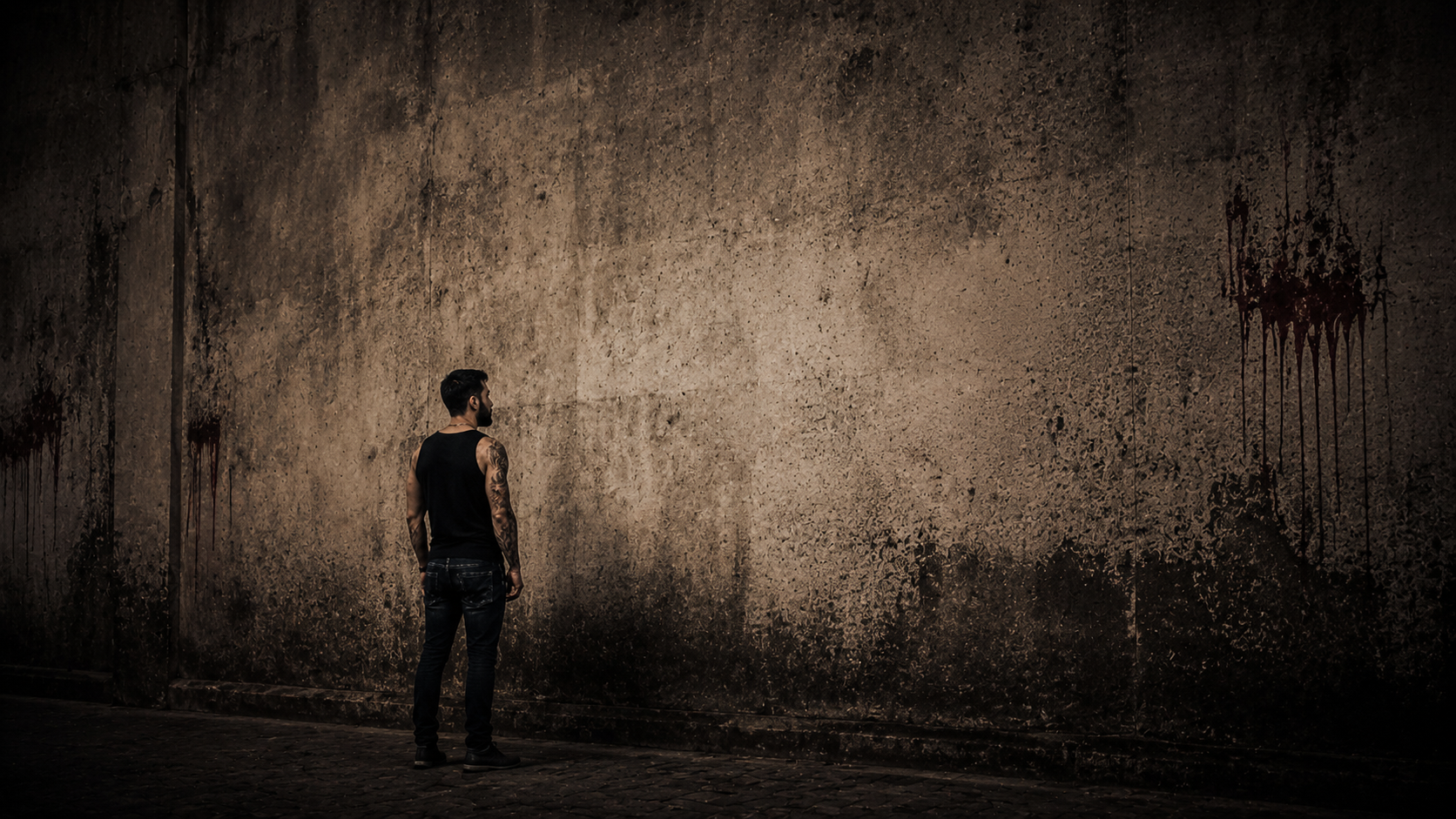 Erediel Molina pequeño ante una pared enorme y oscura.